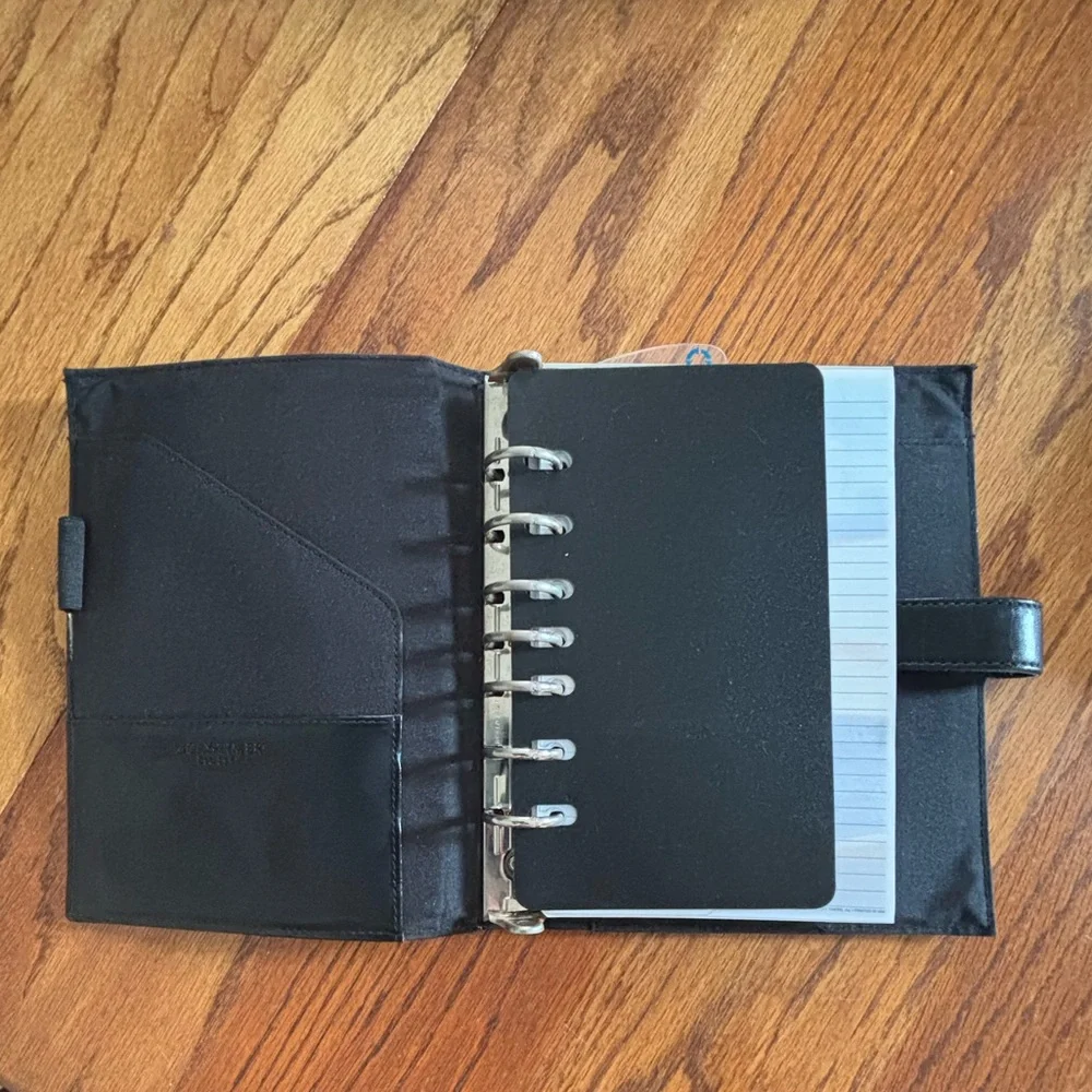Black Leather (?) Day Timer Planner with Extra pages.